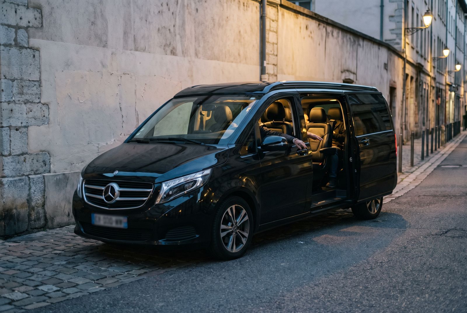Van premium noir porte latérale ouverte, prêt pour un transfert vers les stations de ski